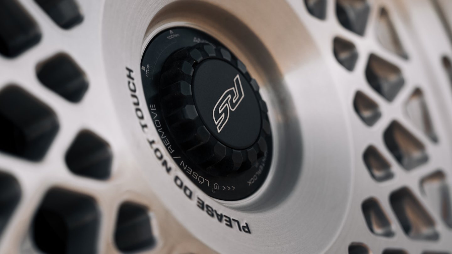 Close-up of a brushed multi-spoke mesh alloy wheel with a centre-lock cap