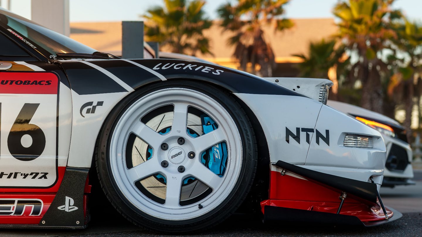 Lowered race-liveried sports car with a front splitter, canards and wide side skirts