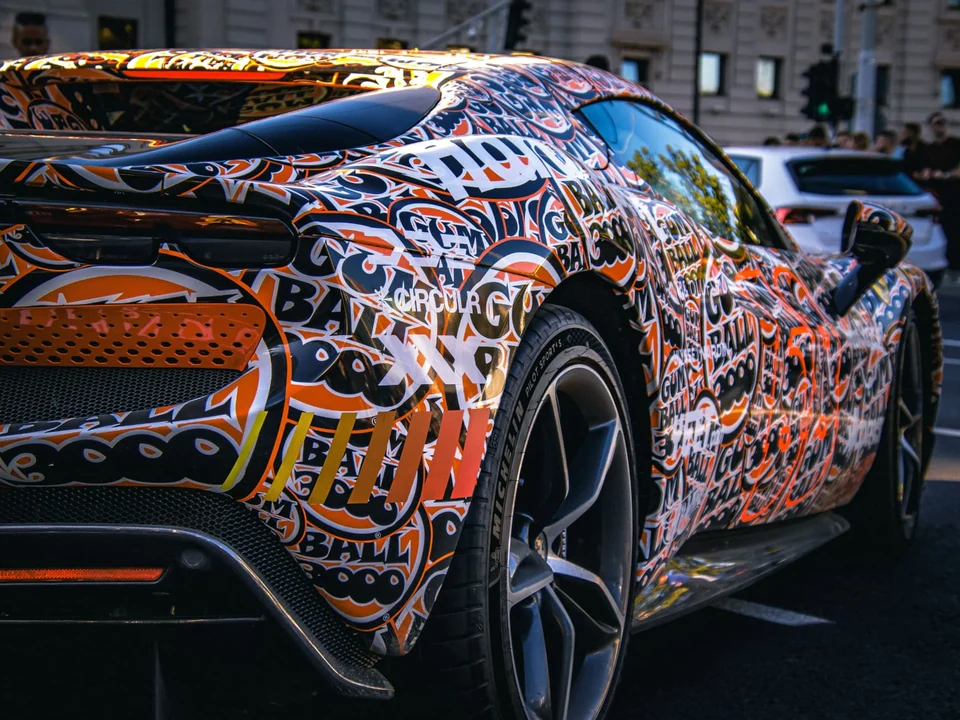 Sports coupe with a detailed orange, white and black custom graphic livery