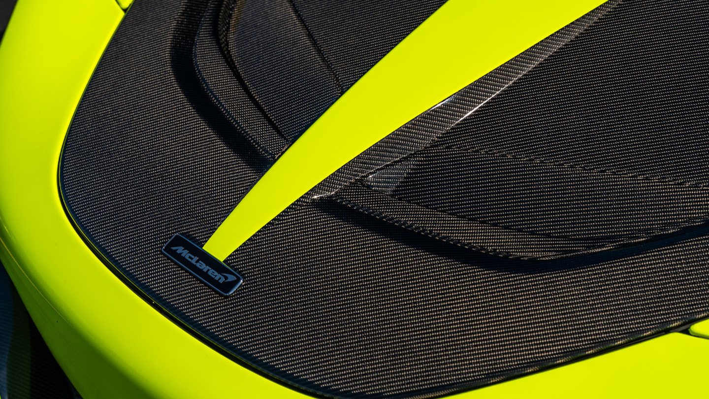 Woven carbon fibre hood ducts and badge on a lime green supercar